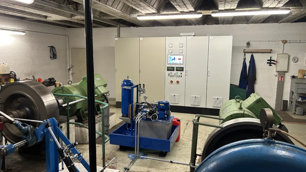 Maxhütte Bergen Turbinenhaus Francis-Spiralturbinen Maxhütte Bergen Blick in der Maschinenhalle auf zwei Fracis Spiralturbinen, einer neuen Hydraulik mit Proportionalventilen, im Hintergrund der neue Steuerschrank mit Bedienpanel und Tastenfeld mit Zeigerinstrumenten.